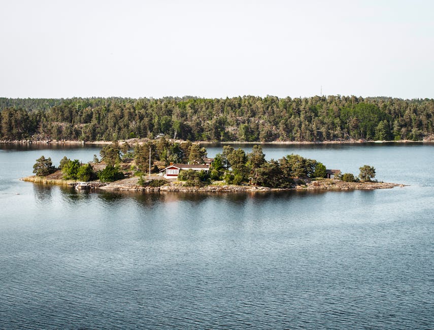 Stockholm archipelago with a small red wooden cottage on a small island surrounded by Baltic water