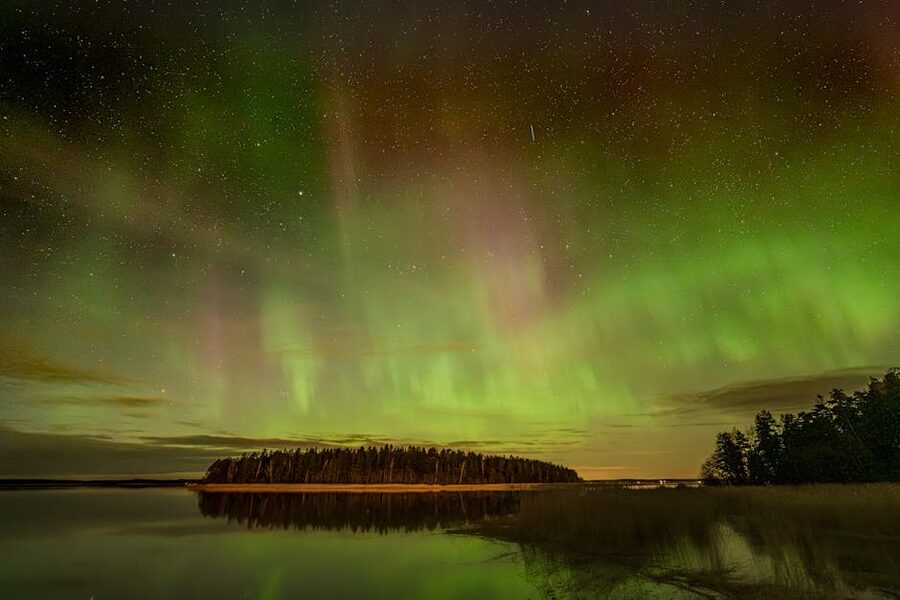 Northern lights reflected on a calm Finnish lake