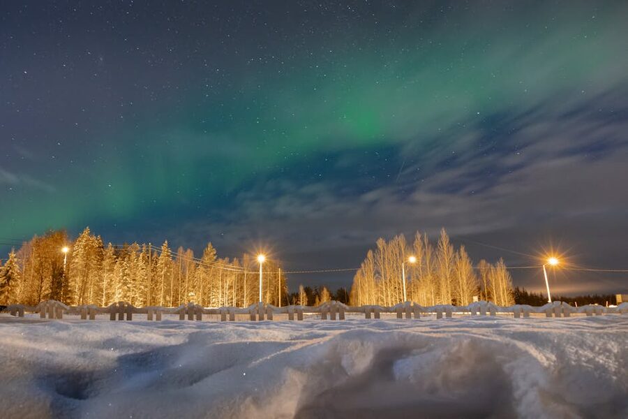 Aurora over a snowy Lapland landscape at night