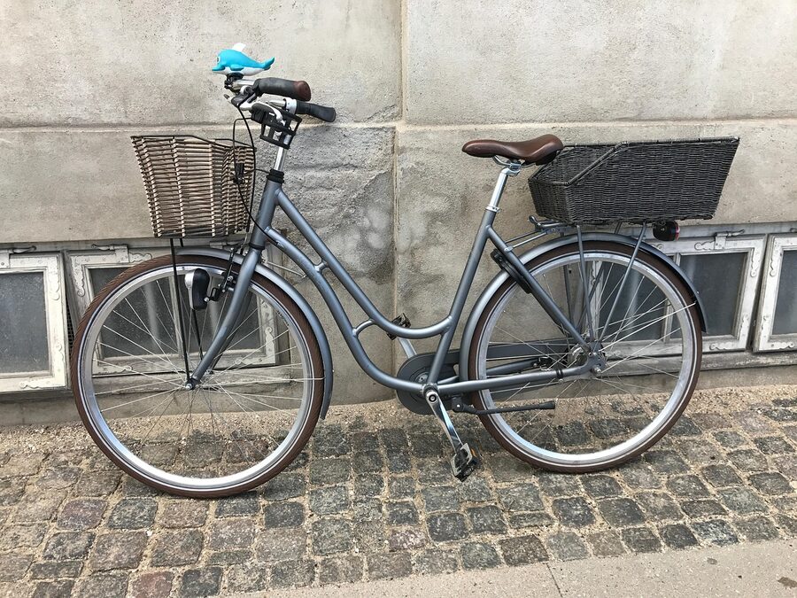 Bicycle on a Copenhagen cobblestone street, leaning against the kerb