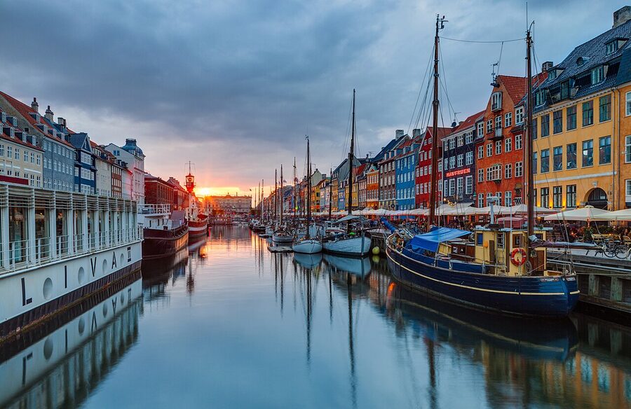 Nyhavn waterfront at sunset with colourful 17th-century houses and moored sailing boats