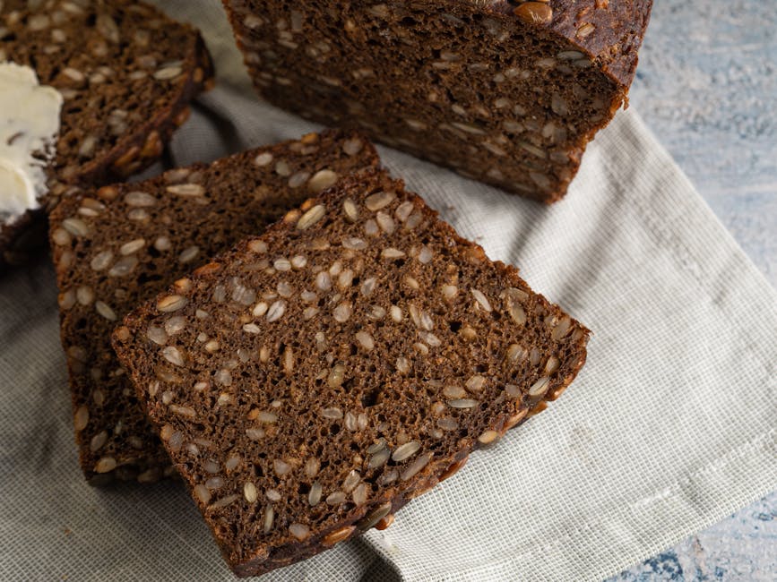 Sliced Danish rye bread with seeds resting on a linen cloth