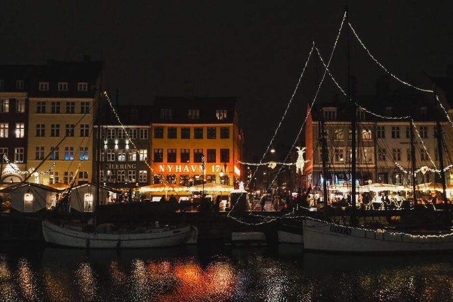 Nyhavn at night with festive lights reflected on the canal water