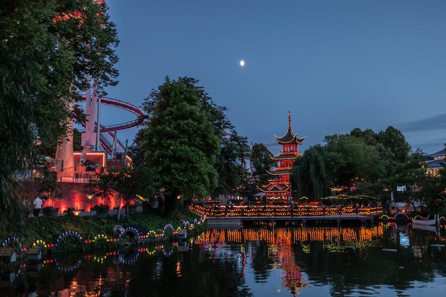 Tivoli Gardens at night with illuminated pagoda reflected in the lake