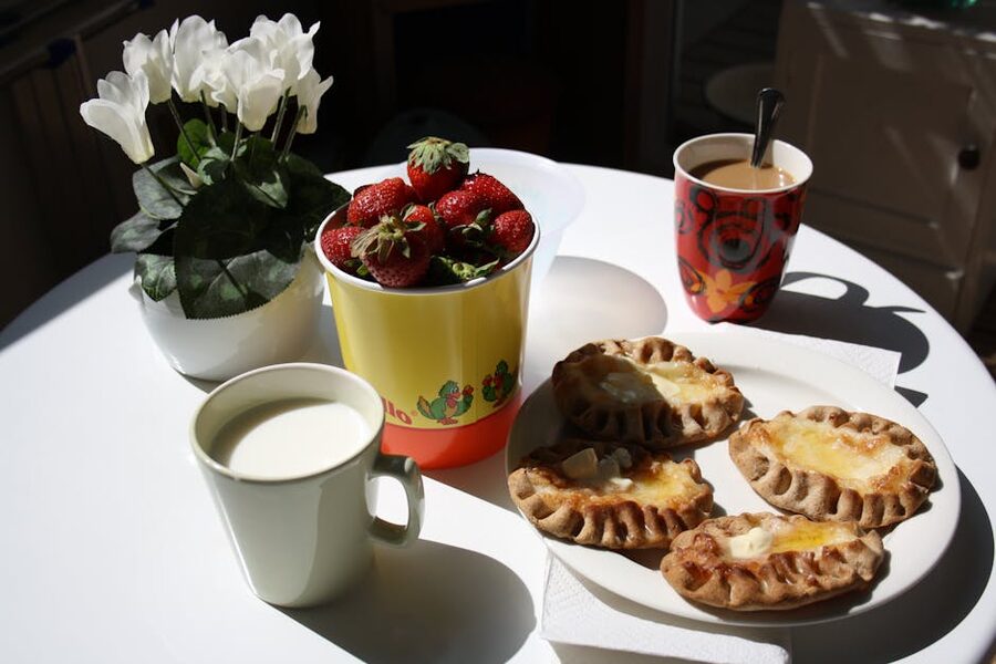 A traditional Finnish breakfast spread with coffee, pastries and strawberries on a sunny morning table