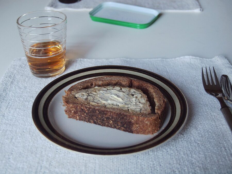 A slice of kalakukko alongside a glass of beer at a Finnish lunch