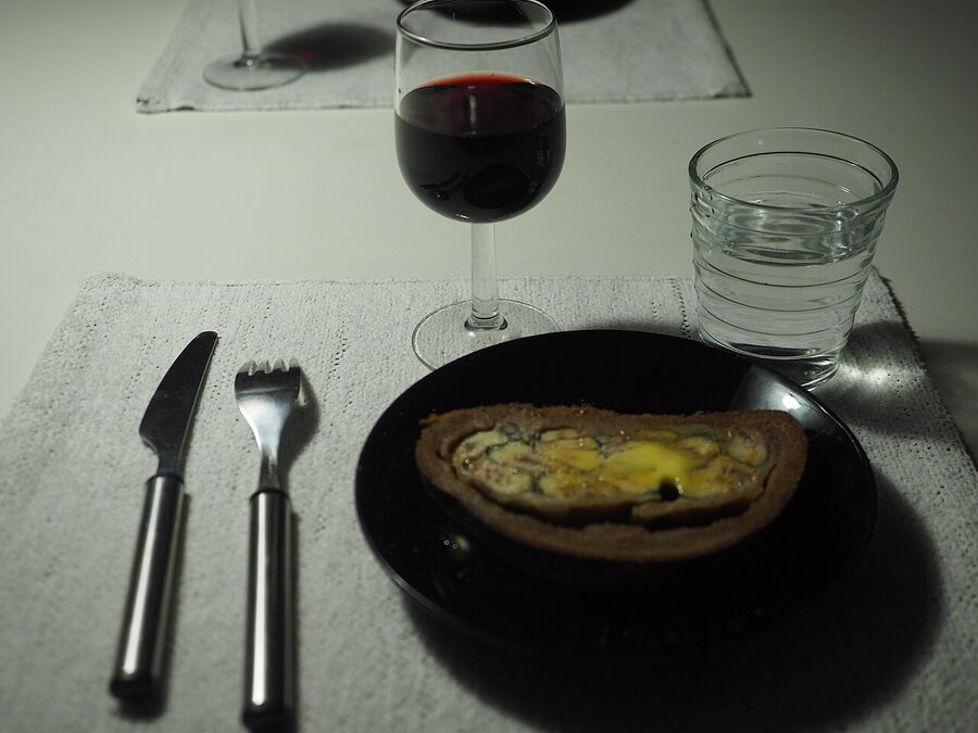 Kalakukko served with red wine on a wooden board