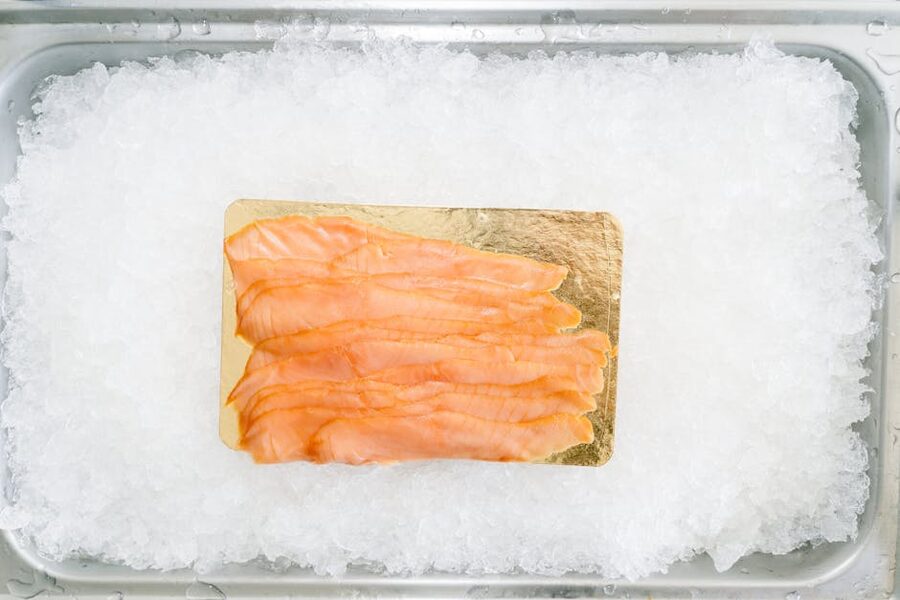 Thinly sliced smoked salmon arranged on ice in close-up