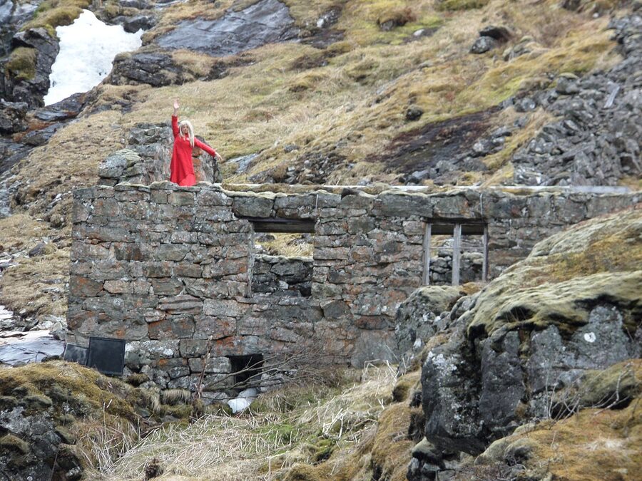 Huldra dancer in red appearing from the rocks at Kjosfossen waterfall
