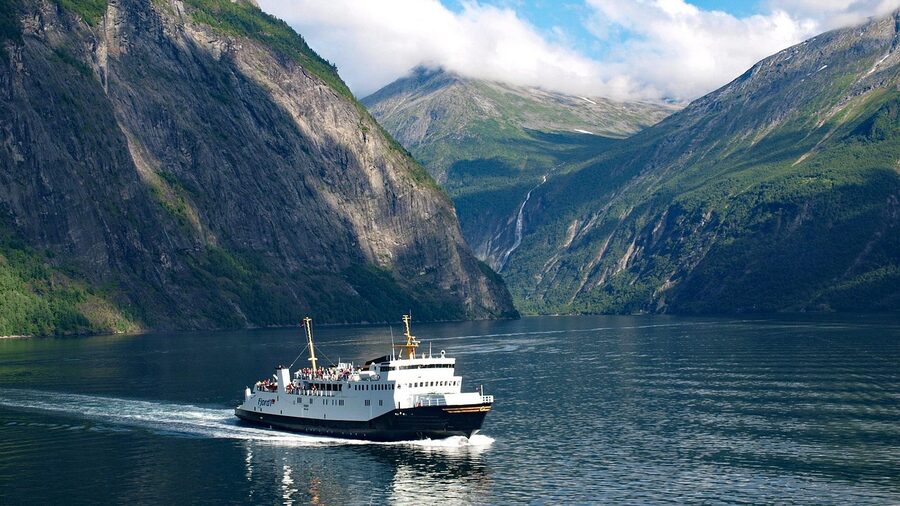 Ferry passing through Geirangerfjord with steep walls