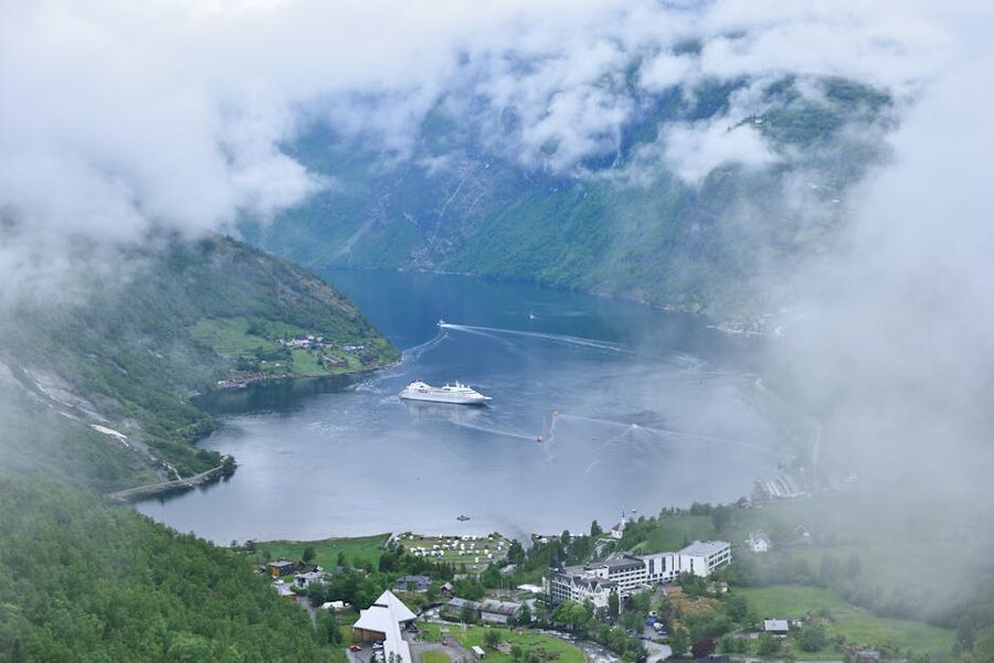 Aerial view of a cruise ship in Geirangerfjord with green slopes around
