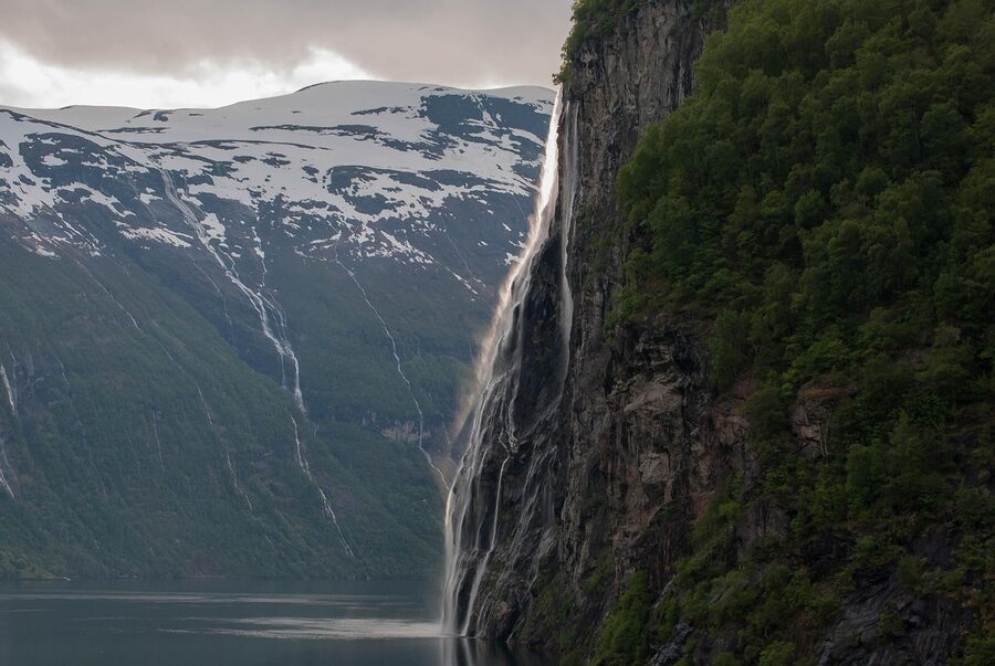 Geirangerfjord with waterfall and snow-streaked peaks