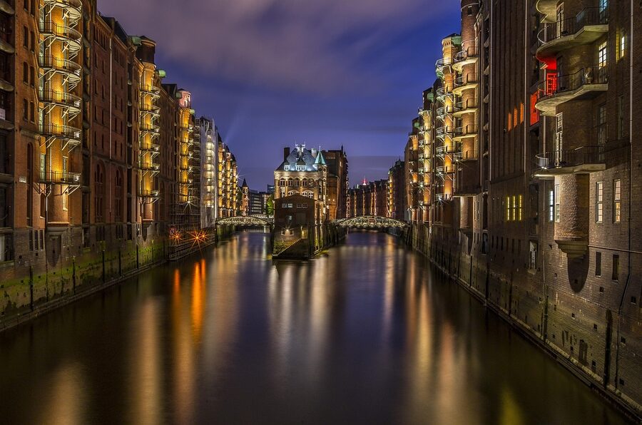 Speicherstadt at night, warehouses illuminated and reflecting in the canal