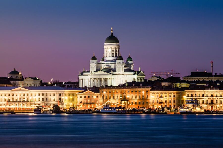 Helsinki Cathedral lit up at dusk reflecting in the South Harbour
