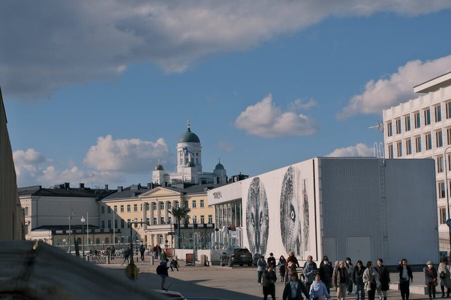 Pedestrians on Helsinki's Senate Square in summer with the cathedral behind