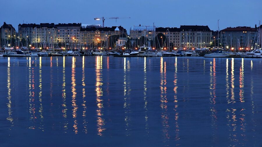 Helsinki harbour at night with reflections of city lights on the water