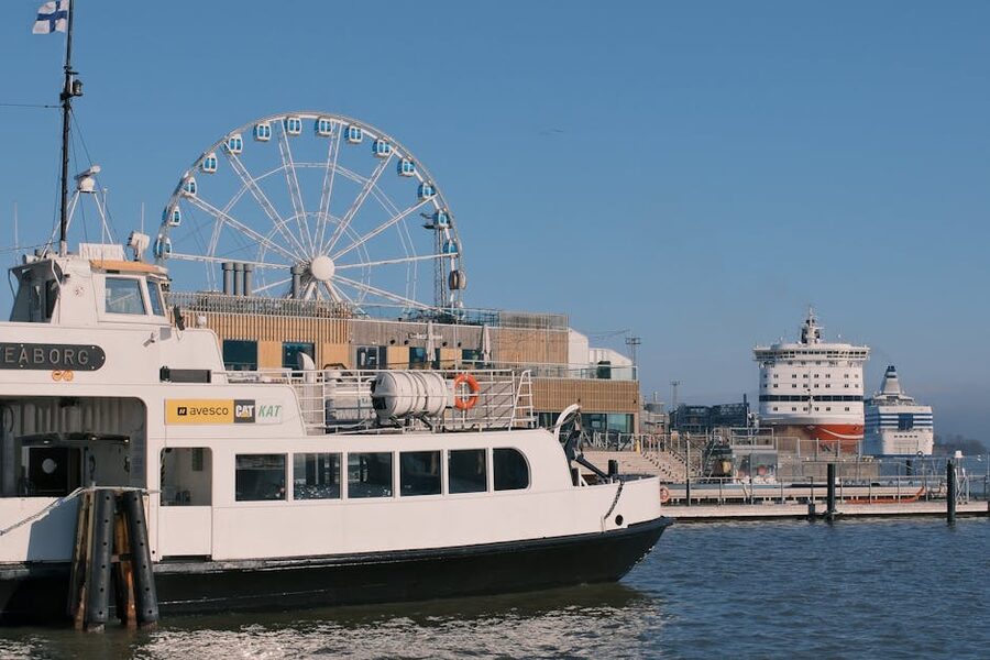 Helsinki harbour scene at the South Harbour with ferries and a Ferris wheel under blue sky