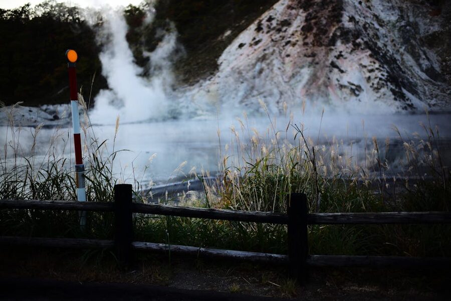 Steam rising from a thermal spring with rocky surroundings