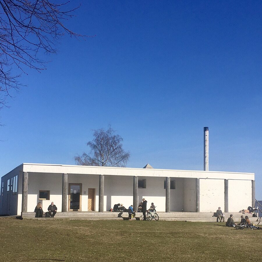 The exterior of Kulttuurisauna in Hakaniemi, a small minimalist concrete building by the sea