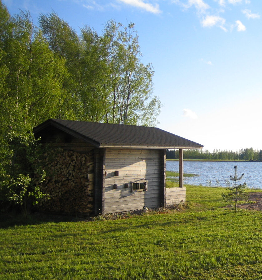 A traditional Finnish smoke sauna, low wooden building with smoke-stained walls