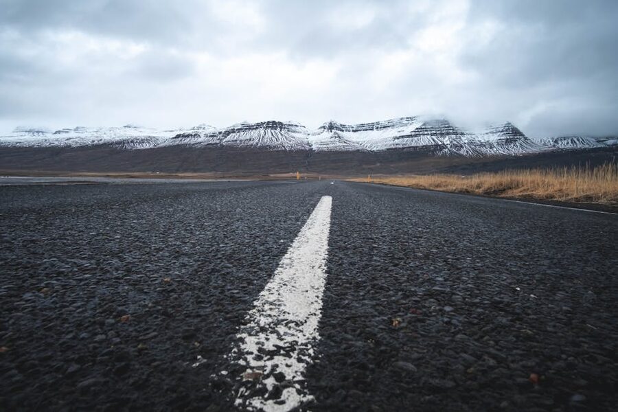 Iceland gravel road towards snow-capped mountains