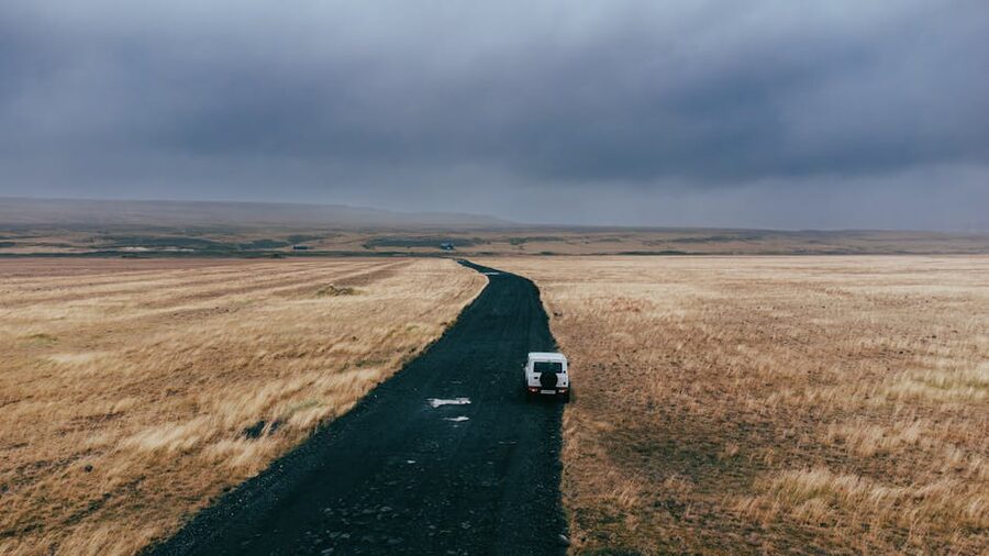 Lone car on a rugged overcast Iceland road