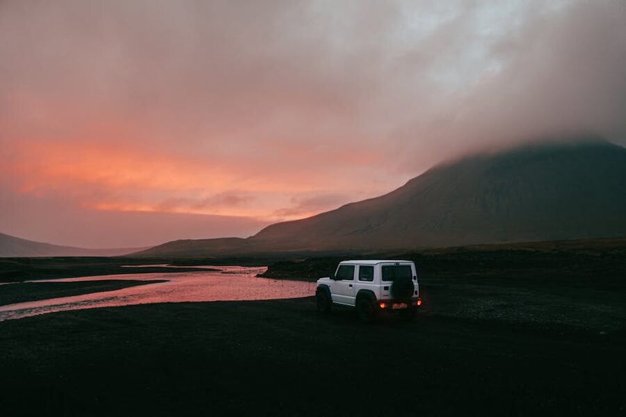 A white Suzuki Jimny by an Iceland river crossing