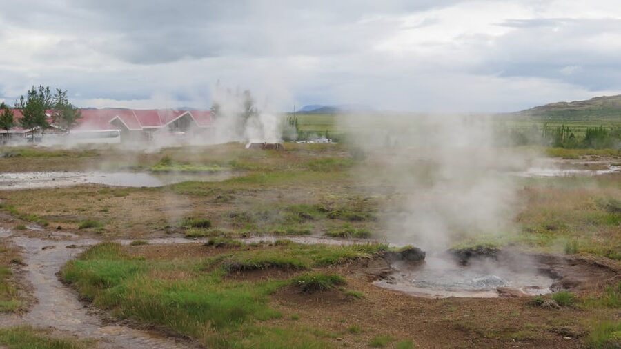 A geothermal pool with steam rising in the Icelandic landscape