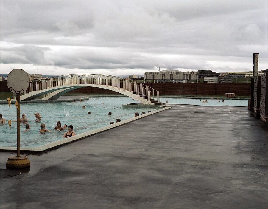 A wider view of the Laugardalslaug pool complex showing the hot pots and outdoor benches