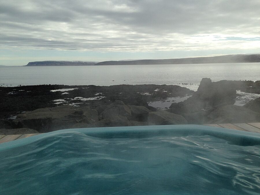 The Drangsnes hot pots at sunset with steam and the Atlantic behind