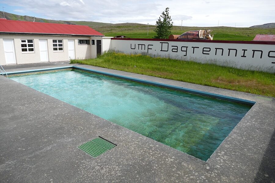 A small village swimming pool in rural Iceland with a wooden building