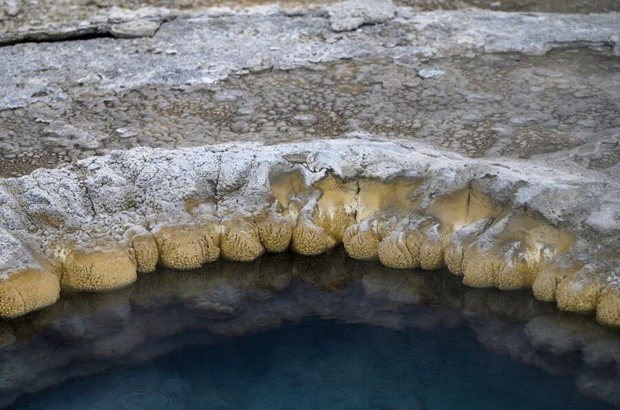 A close-up of a natural rock formation around a geothermal pool
