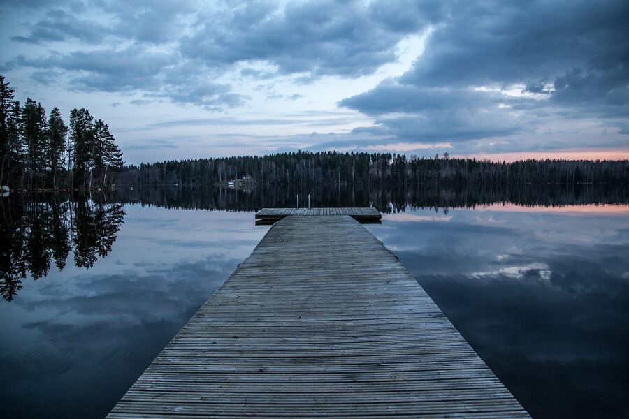 Wooden jetty extending into a Finnish lake at sunset