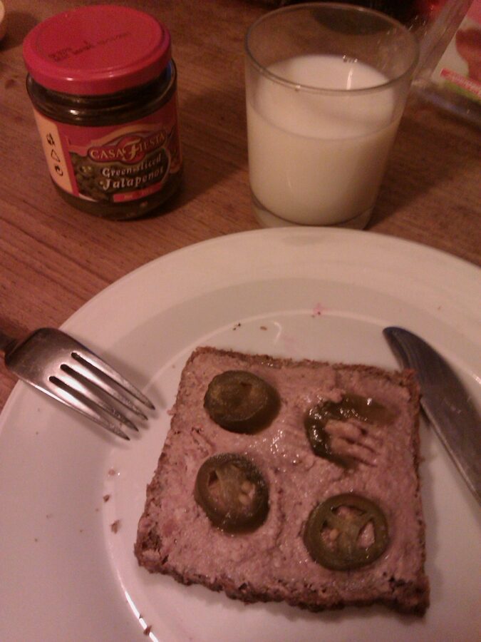 Leverpostej (Danish liver pâté) on rugbrød with bacon and pickled cucumber