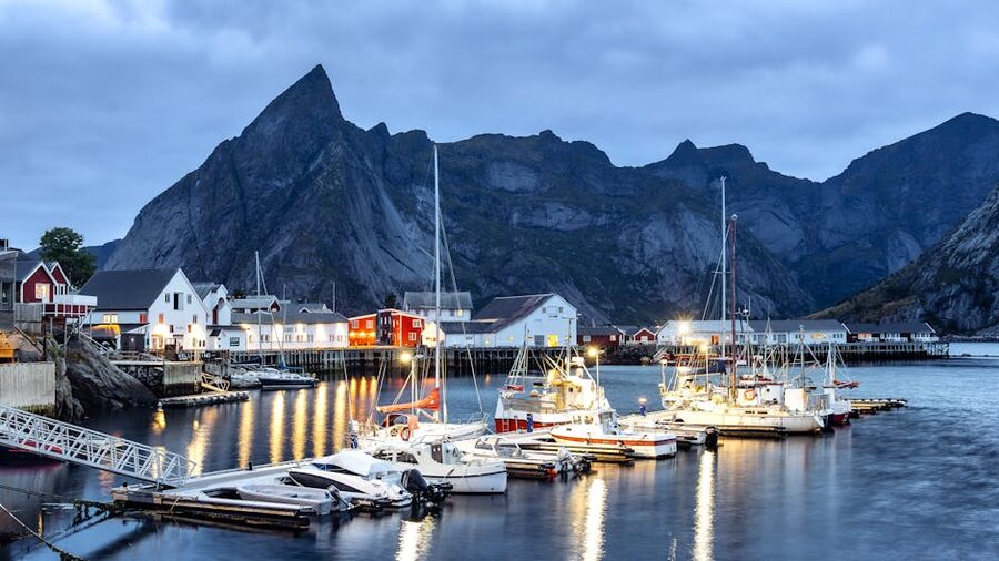 Reine harbour in Lofoten with red rorbu houses and dramatic mountains