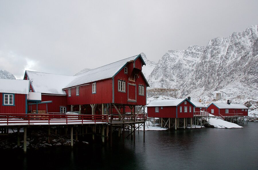 Red stilt houses at Å in Lofoten reflected in calm water