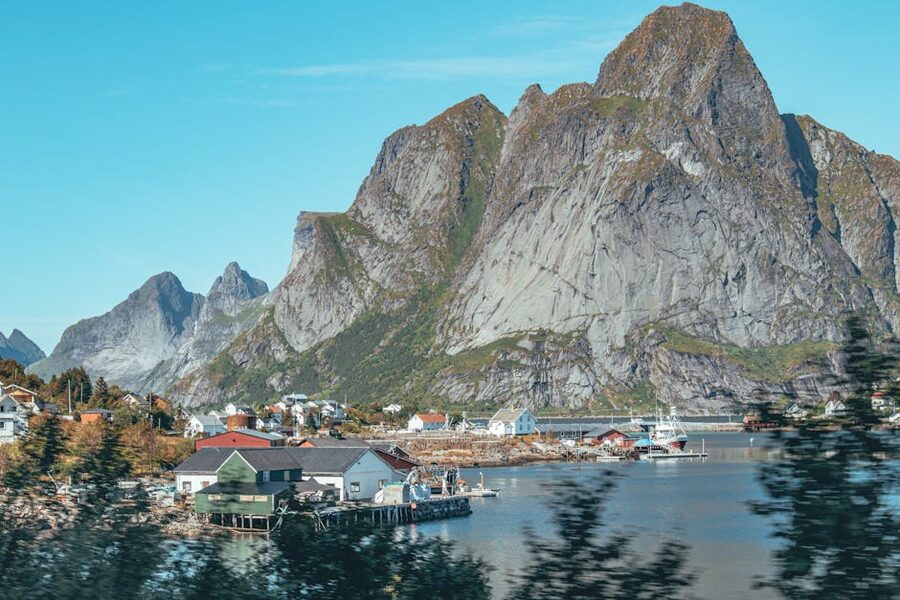 Lofoten village by fjord with cliffs and boats