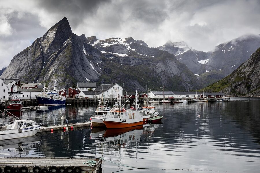 Boats moored in Reine harbour with mountain backdrop
