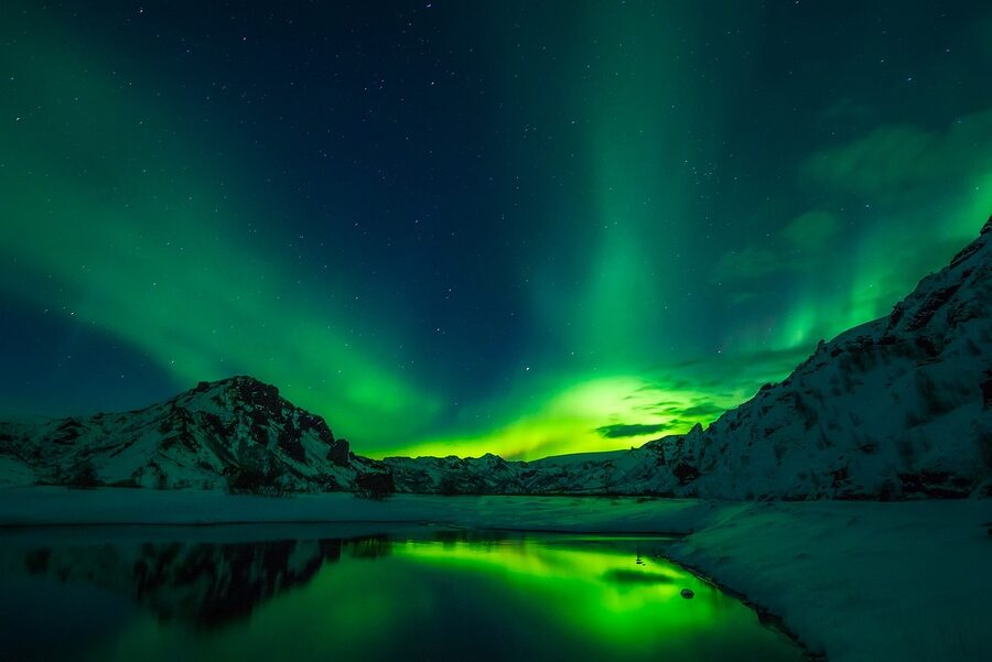 Aurora borealis over a calm lake on a clear winter night