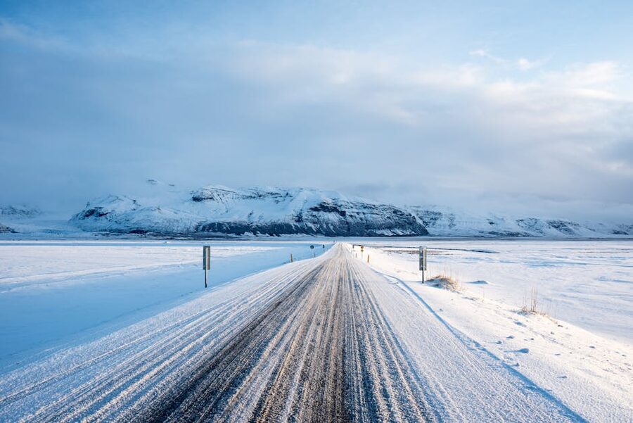 Snow-covered road leading toward mountains in Vík í Mýrdal, Iceland