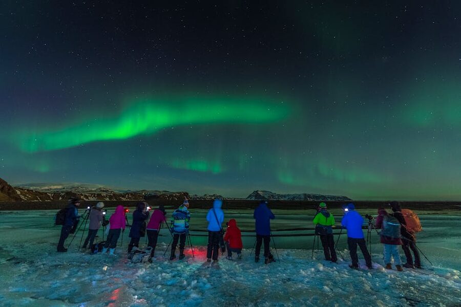 Group of photographers capturing the aurora borealis in Iceland