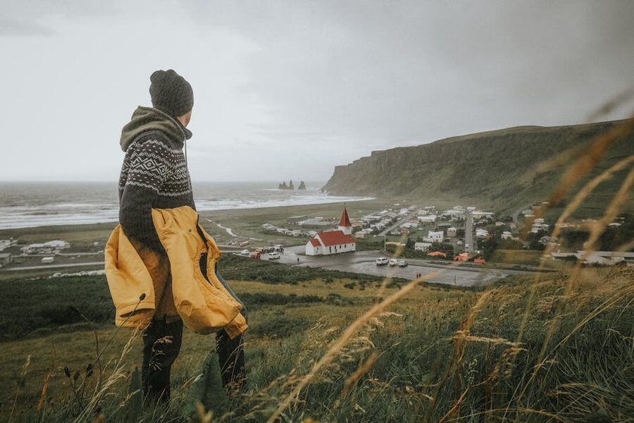 A person in warm clothing overlooking the Vík landscape, Iceland