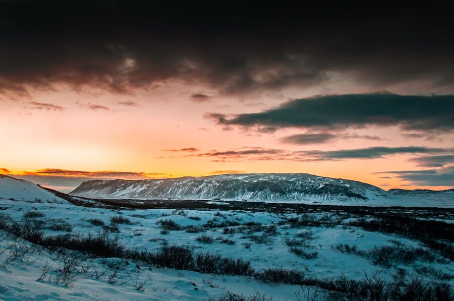Snowy Icelandic landscape at sunset with dramatic clouds