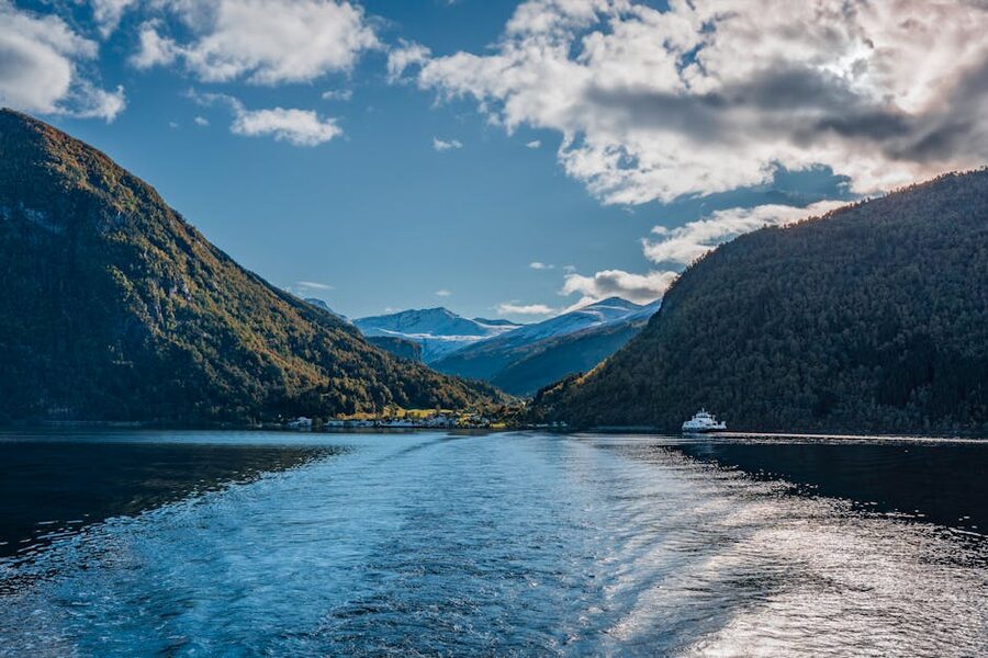 Ferry crossing a Norwegian fjord with steep mountains behind