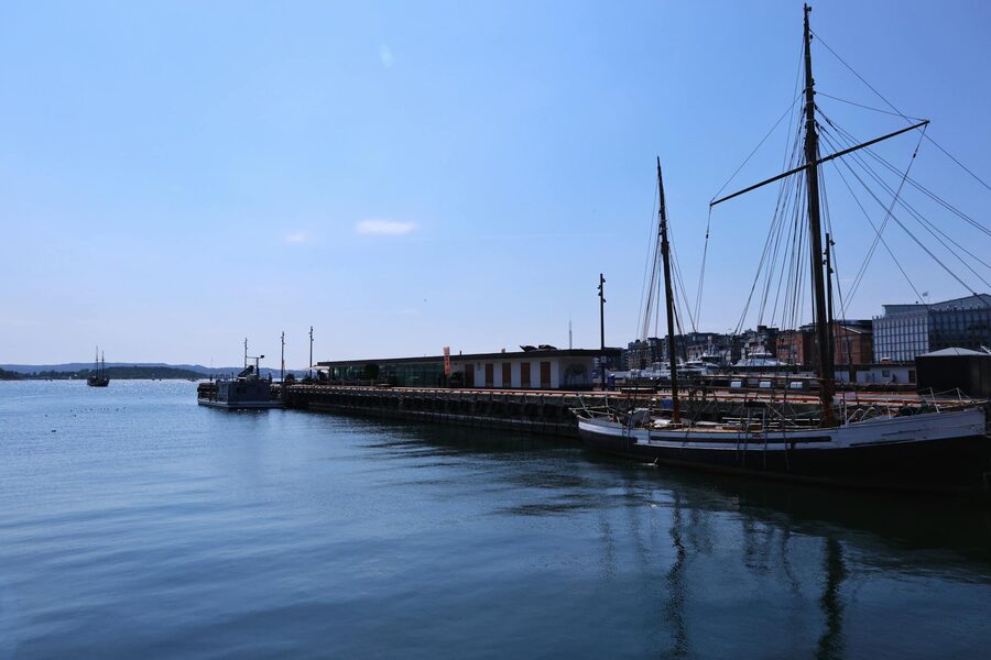 Sailboats anchored in Oslo's marina with city skyline behind