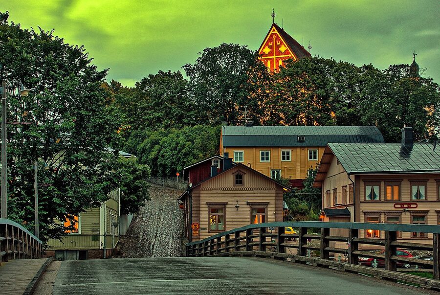 Vanha Porvoo Old Town at night seen from the bridge with lit windows and reflections in the river