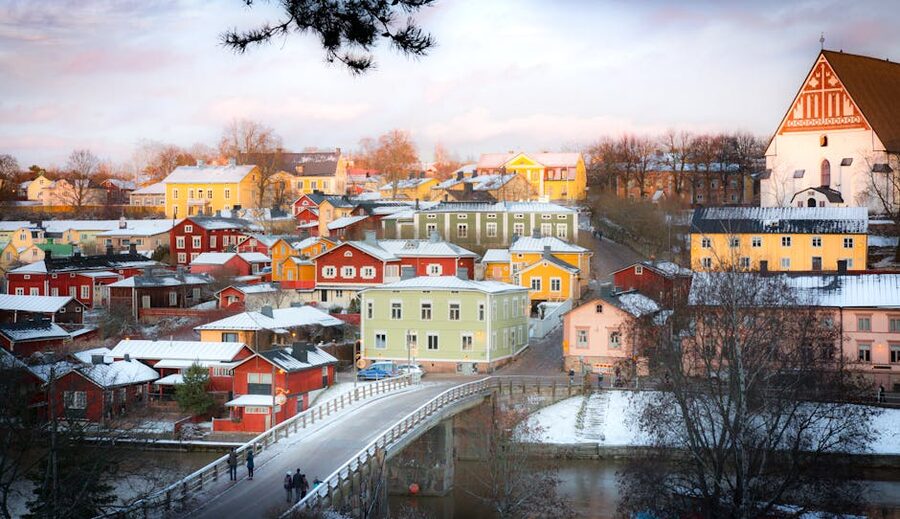 Porvoo's colourful wooden houses in winter, snow on roofs, frozen river, soft cold light