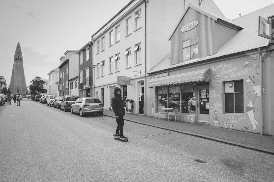 Skateboarder on Rainbow Street with Hallgrimskirkja behind
