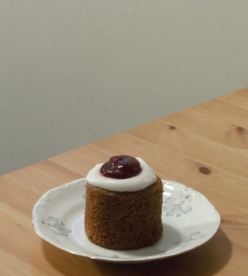 A Runeberg torte with a coffee cup, on a wooden table, in classic Finnish coffee-break presentation