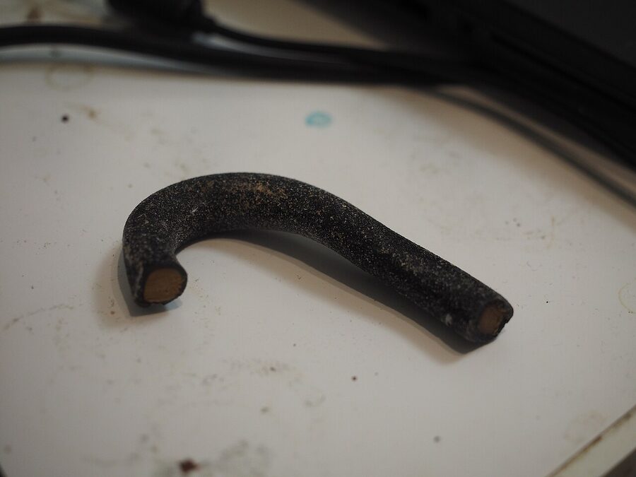 A piece of salty liquorice candy rope, the Finnish salmiakki, dark and matte